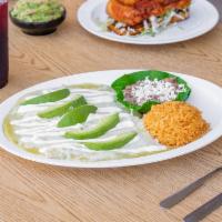 Enchiladas Suizas · 3 enchiladas stuffed with chicken and cheese, topped with a creamy green sauce, sour cream a...