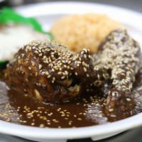 Pollo Con Mole Plato · The traditional ancient recipe served with two pieces of chicken smothered in mole poblano, ...