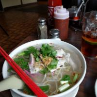 Tom Yum Pork Noodle Soup · Rice noodle soup with sliced pork, Chinese BBQ pork and bean sprouts in a savory sweet, sour...