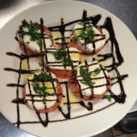 Caprese Salad · Fresh tomatoes topped with mozzarella cheese, fresh basil, balsamic vinegar and olive oil.