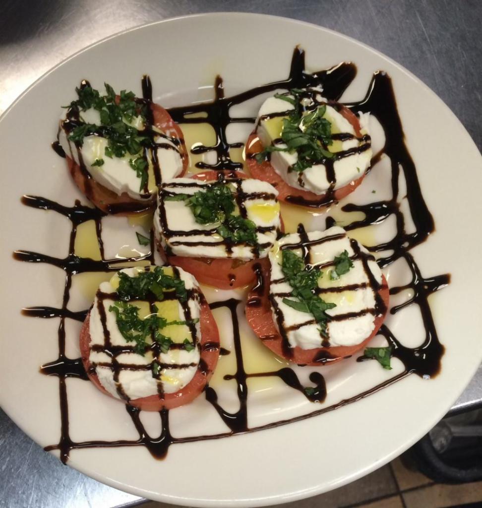 Caprese Salad · Fresh tomatoes topped with mozzarella cheese, fresh basil, balsamic vinegar and olive oil.