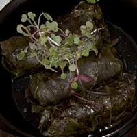 Tolma · Grape leaves stuffed with lamb and rice. Served with yogurt and garlic dressing.