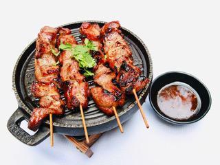 GARLIC PORK STICKS · 4 pieces. Moo pieng. Grilled pork skewers marinated in garlic and Thai spices. Served with sweet chili sauce.