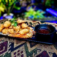 CRISPY FRIED CALAMARI · Tod pla muk. Calamari strips marinated and breaded in Thai spices, deep-fried golden. Served...