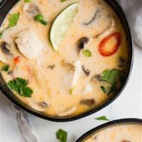 TOM KHA · THAI GINGER SOUP. Tom yum broth lightly sweetened with creamy coconut milk. Garnished with g...