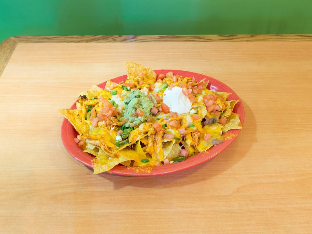 Super Nachos · Chips covered in cheese and beans topped with jalapenos, guacamole, sour cream, tomatoes and green onions. Add meat chicken, ground beef or shredded  beef for an additional charge.