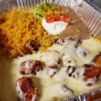 46. Camarones Costa Azul · 9 shrimp wrapped in bacon over a bed of onions covered in melted cheese. Served with rice, b...