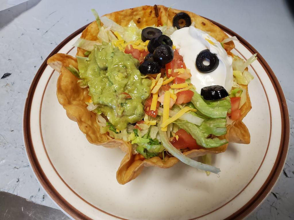 Taco Salad · A crisp deep dish flour tortilla with beans, choice of meat, lettuce, tomatoes, black olives, sour cream, guacamole and cheese.