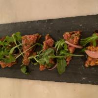 Steak Tartare  · Dressed with capers, Dijon, and cornichons served on toasted housemade focaccia with arugula...