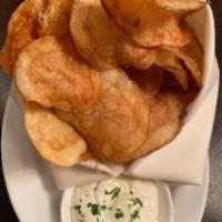 Crisps  · Housemade potato chips tossed in duck fat served with a truffle creme fraiche.
