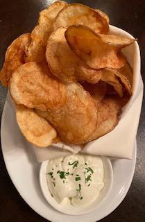 Crisps  · Housemade potato chips tossed in duck fat served with a truffle creme fraiche.
