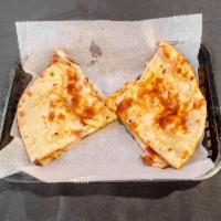 Plain Naan · Flat bread baked in the tandoor oven and drizzled with butter.
