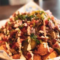Tot Chos · Crispy tots covered in nacho cheese, beer-braised pulled pork, red onion, jalapeno, tomato, ...