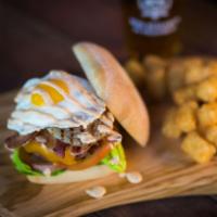 The Hangover Cure Burger · Applewood-smoked bacon, avocado, grilled onion, cheddar cheese, garlic aioli, topped with sp...