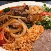 Steak Ranchero · Tender New York sliced steak smothered in our delicious ranchera sauce served with rice, bea...