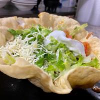 Taco Salad · Crispy tortilla bowl with shredded chicken, refried beans, lettuce, tomatoes, cheese sauce a...