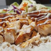 Salmon Teriyaki · Tender grilled salmon on a bed of steamed white rice and drizzled in homemade teriyaki servi...
