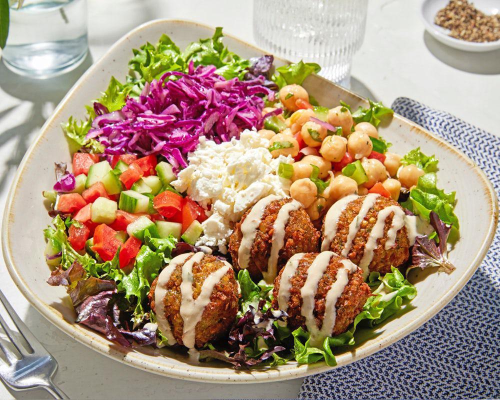 Vegetarian Bowl · Housemade falafel served on top of a bed of lettuce with lemon vinaigrette, Greek cabbage, feta, chickpea salad, cucumber and tomato, drizzled with vegan tahini sauce. 
*Vegetarian, Gluten Free, High Protein (23G), 730 Cals