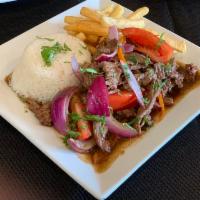 Lomo Saltado · No substitution. Tender steak mixed with onions and tomatoes served over french fries and ri...