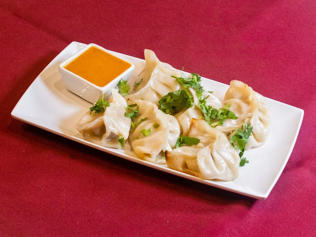 Mo Mo · 6 pieces. Steamed dumplings choice of chicken or vegetables, side of tomato.