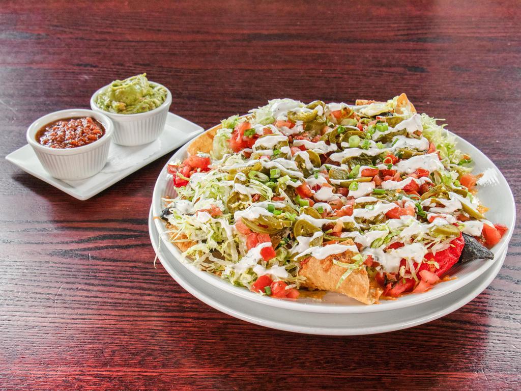 Texas Chili Nachos · Terlingua chili, Monterey Jack and cheddar cheese, pico de gallo, scallions, black beans, house pickled jalapenos, sour cream, shaved lettuce, charred tomato salsa, guacamole. Add chicken for an additional charge.