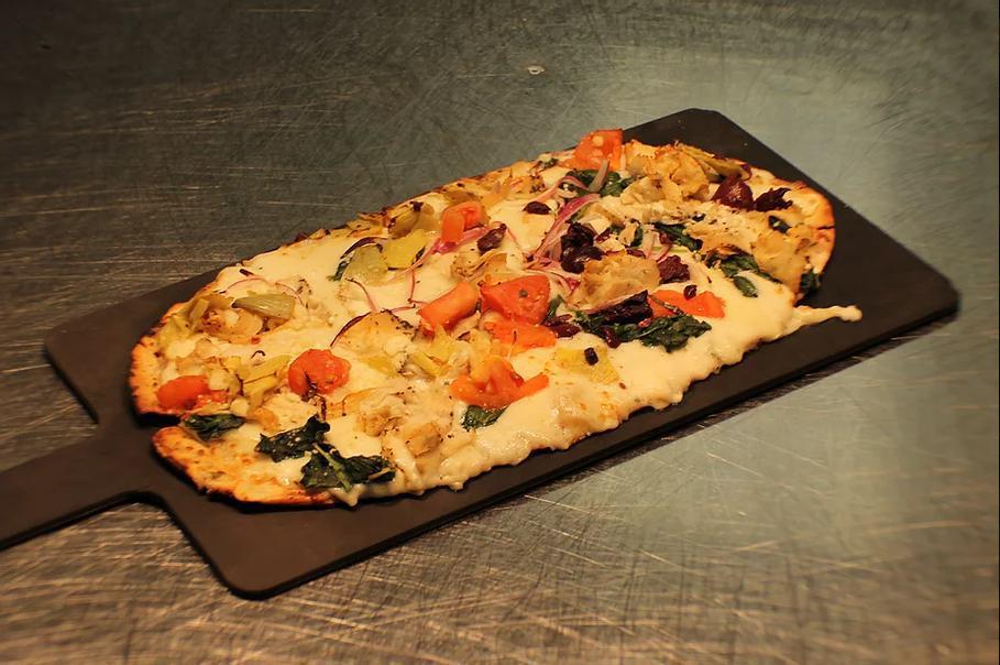 Vegetarian Flatbread Pizza · Roasted peppers, mozzarella, caramelized onions, roasted garlic, tomatoes, arugula, olives, mushrooms.