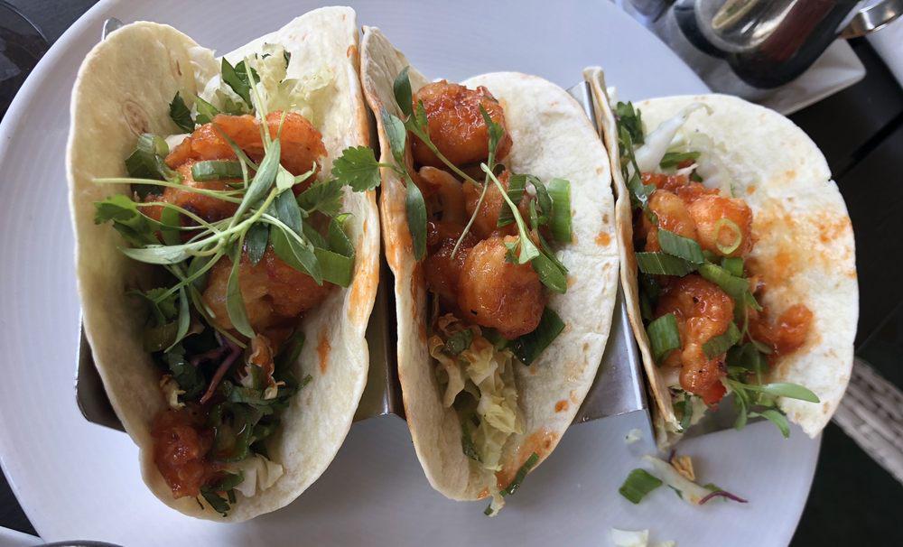 Pow Pow Shrimp Tacos · Tempura shrimp tossed in pow pow sauce with lime dressed slaw and micro cilantro served with black beans and rice.
