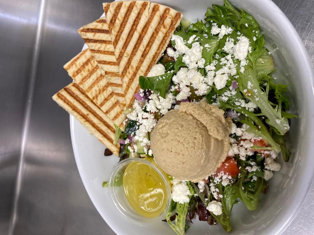 Greek Salad · Mixed greens, kalmata olives, tomato, cucumber, feta, red onion, tossed in our lemon olive oil dressing with hummus and pita.