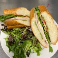 French Connection Sandwich · Turkey, provolone, pesto, lettuce and tomato on baguette. Baked bread.