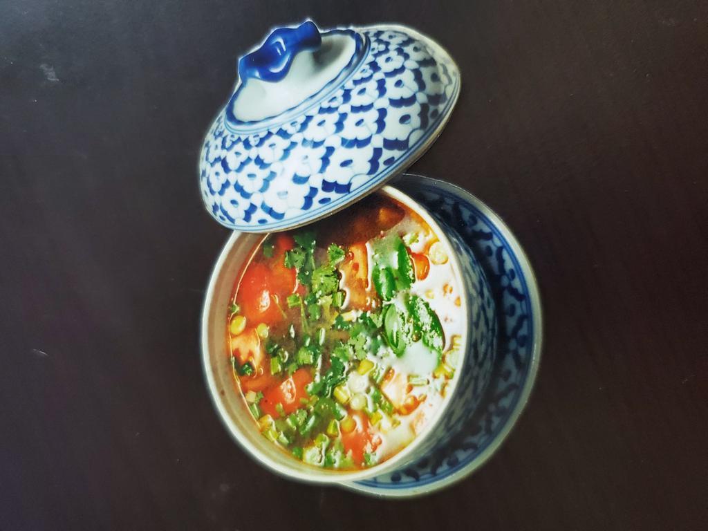 S3. Tom Yam Soup · Spicy lemon grass soup with chili paste, straw mushroom, onion, and cilantro.