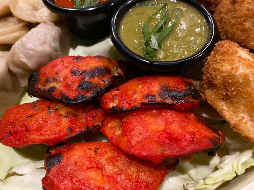 Tandoori Paneer Momo · 8 pcs of Momos are bite-size dumplings with Paneer filling cooked in Tandoor, wrapped in a dough accompanied by spicy dipping sauce.