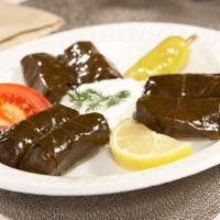 Stuffed Grape Leaves Appetizer · Cooked grapevine leaves stuffed with rice and spices, served with side of cucumber sauce and...