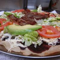 Tlayuda Una Carne · Large Oaxacan corn tortilla, toasted and topped with aciento, black beans, quesillo, cabbage...
