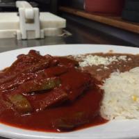 Costilla de Puerco en Salsa Roja con Nopales · Pork ribs and cactus in a spicy red chile salsa. Served with rice and beans. Servido con arr...