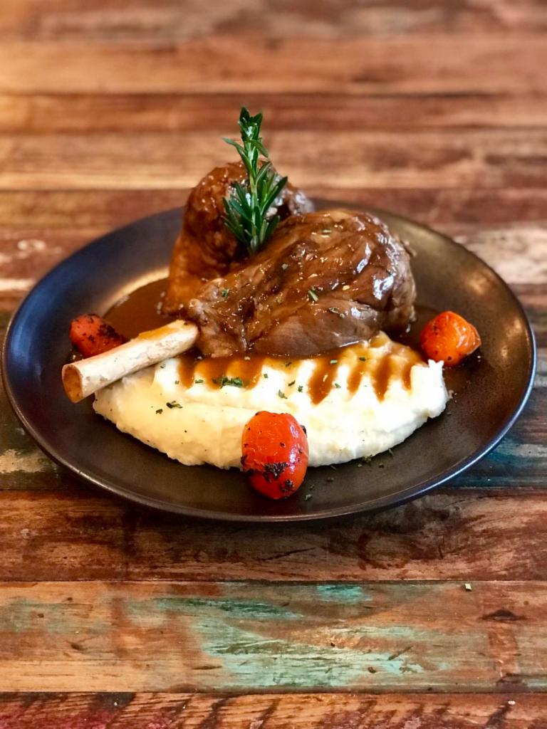 Lamb Shanks · Slow cooked lamb shanks served over cheesy mashed potatoes with demi-glace sauce.