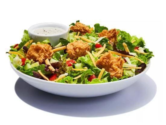 Chicken Garden Salad · Spring mix greens piled with diced tomatoes, crisp cucumbers, cheddar cheese, Monterey Jack cheese and croutons and your choice of salad dressing. Topped with grilled or fried chicken.