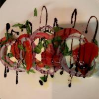Caprese Salad · Fresh mozzarella layered with slices of tomatoes, fresh basil, red onions, roasted red peppe...