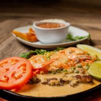 May y Tierra · Churrasco con camarones en salsa de mariscos and ribeye steak with shrimp topped with garlic...