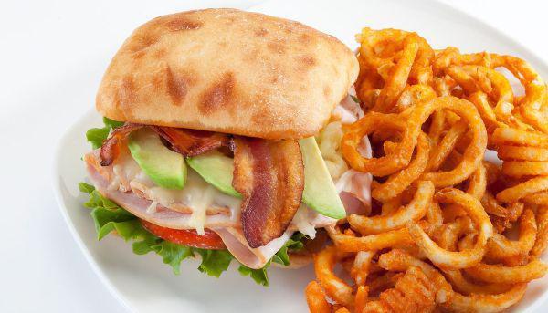 California Club Sandwich · Smoked turkey, jack cheese, bacon, sliced avocado on a toasted ciabatta bun, lettuce and tomato on the side.