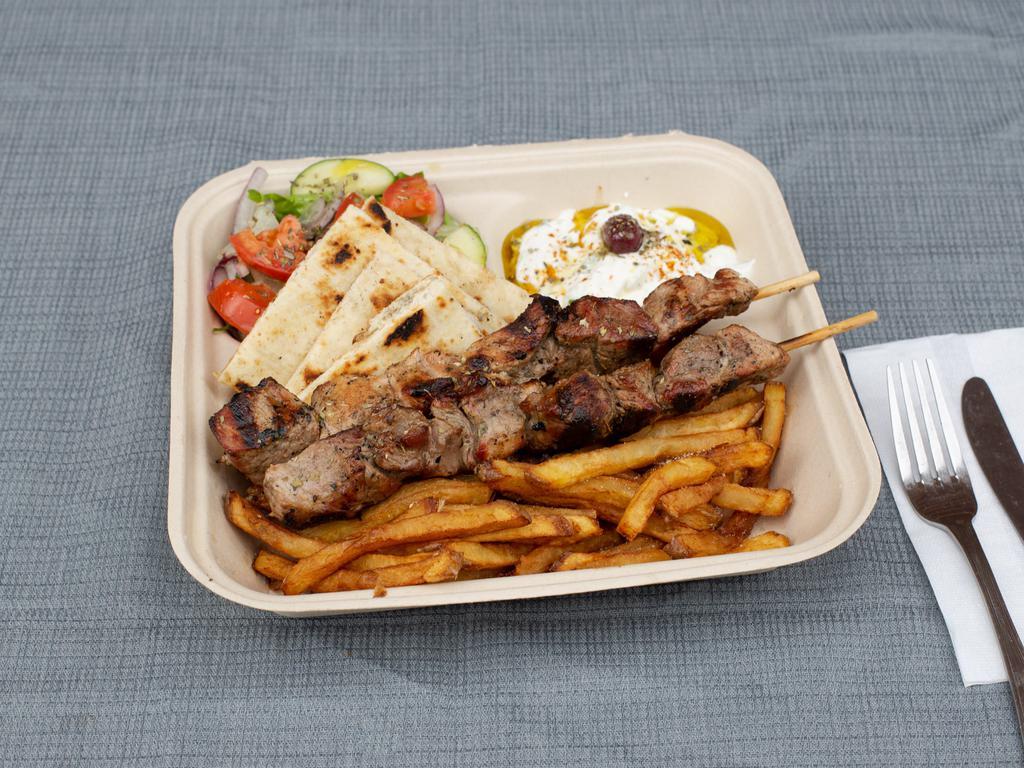 Pork Souvlaki Platter · 2 sticks of our hand skewered pork souvlaki over our handcut fries or yellow rice. Comes with a side salad and your choice of bread, sauce, and toppings. 