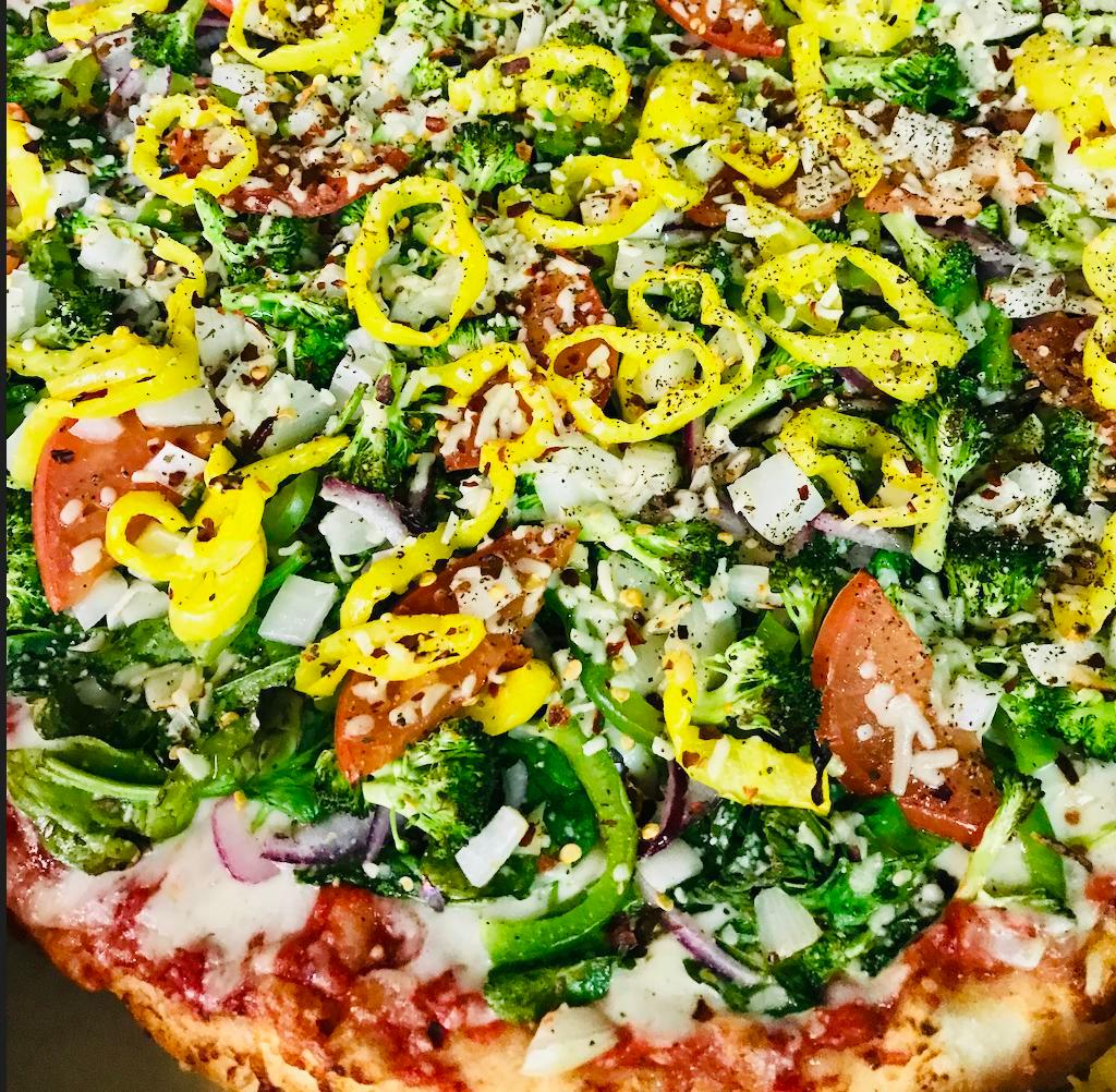 Veggie Extreme Pizza · This Baby has our Homemade Red Pizza Sauce with Freshly Shredded Mozzarella, Fresh Baby Spinach, Sliced Red Onions, Green Peppers, Sliced Tomatoes, Fresh Broccoli, Pickled Banana Peppers, Diced Yellow Onions, Crushed Red Pepper Flakes, Spices & Asiago Cheese