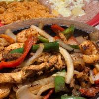 Fajitas Supremas · The ultimate fajitas, steak, chicken and shrimp sizzling hot over a bed of sauteed onions, c...