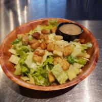 Caesar Salad · Romaine lettuce tossed in our creamy Caesar dressing topped with croutons and Parmesan cheese.