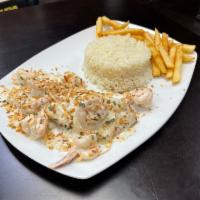 Salmon con Camarones en Salsa de coco · Salmon with shrimp in coconut sauce served with rice and French fries.