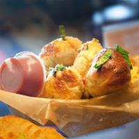 Garlic Knots · House-made dough, tied up, dipped in garlicky goodness and oven baked. Served with warm flip...