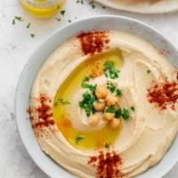 Hummus · A delightful dip of garbanzo beans with garlic, lemon juice, tahini and olive oil. Served wi...