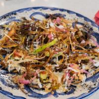 Nachos Don Jaime · Individual round chip spread with black refried beans, topped with Oaxaca cheese, pickled re...