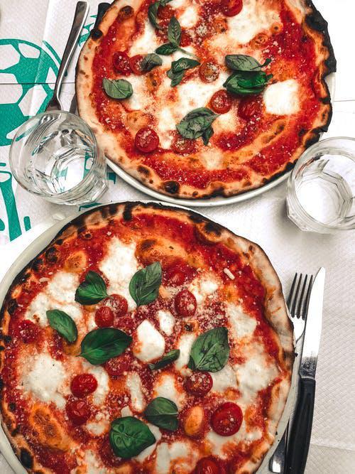Margherita Pizza · Virgin olive oil, Roma tomatoes, fresh basil, Parmesan and mozzarella cheese. Tomato sauce and garlic are optional. Vegetarian.