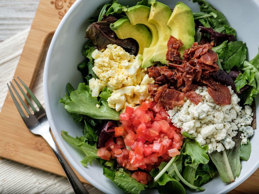 Cobb Salad · Mixed greens, bleu cheese crumbles, bacon, diced egg, tomato, parsley and avocado with sesame ginger dressing. Served with fresh baked bread.