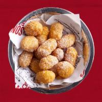 Corn Nuggets · Lightly fried and sweet creamed corn clusters topped with powdered sugar.